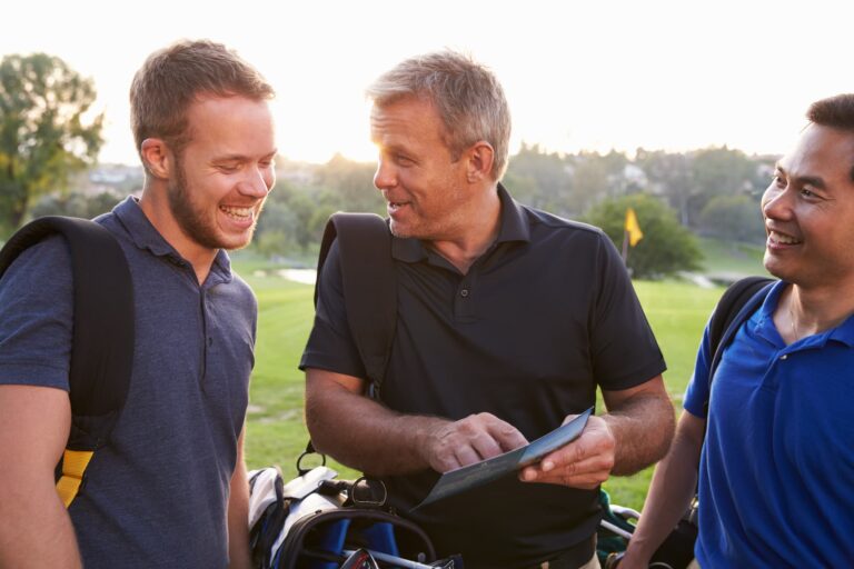 Een groep golfers gebruikt een tablet om hun GVB Halen-scores te analyseren.